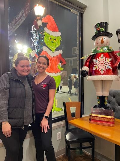 The window artists pose in front of their work.